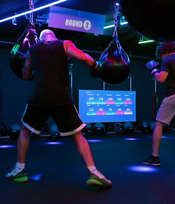 Man performing a controlled strength exercise in a modern, dark gym setting.